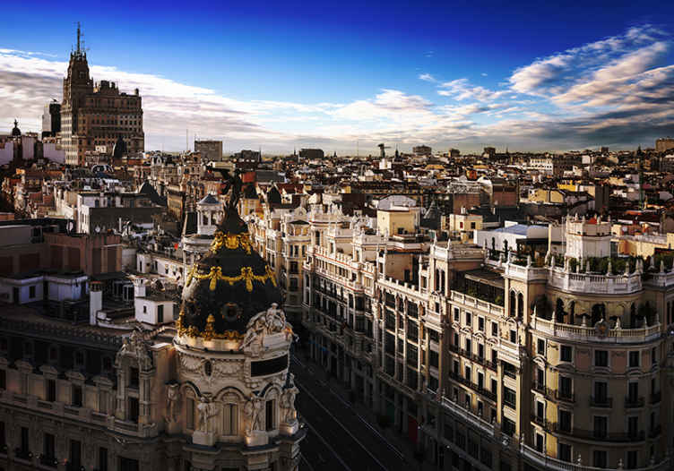 Fotomural Madrid Gran vía con nubes al atardecer - TenVinilo