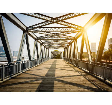 An amazing 3D effect wall mural featuring a lovely bridge with the sun casting its light over the metal bars. Order yours now!
