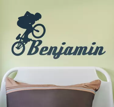 Silhouette wall decal with customizable name and the profile of a young man doing tricks with his bicycle. Anti-bubble vinyl.