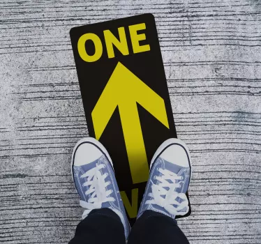 The arrow floor sticker features a yellow arrow with the text one way around it. The sticker is coloured in black and yellow.